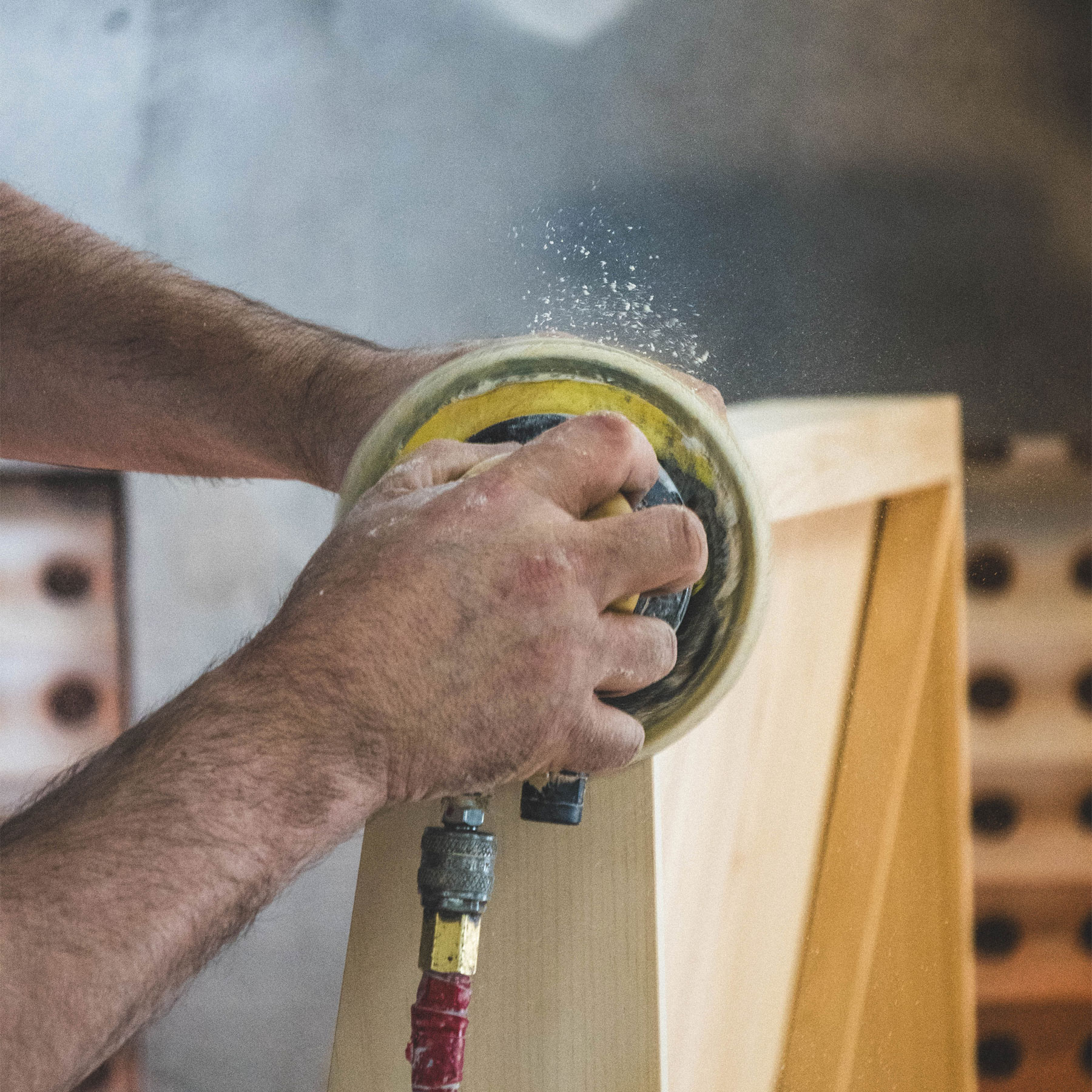 Photographie d'un employé de l'ébénisterie Groupe EBL qui ponce du bois